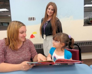 Brelynn Abers, an elementary and middle school tutor for Chautauqua Striders, and a second-grader enjoy one of the books Chautauqua Striders recently received from Prendergast Library as Katelyn Cornell, a social work intern from the library, looks on. Approximately 200 books obtained through the generosity of a book drive by local Time Warner Cable employees and the library’s Family Literacy Fund established by Dan and Linda Fellows are used by students for daily reading sessions at the Striders’ on-site tutoring location at 301 E. Second St., Jamestown. Tutors trained by Chautauqua Striders are also providing the math assistance online for Homework Help. Public libraries in Brocton, Dunkirk, Fredonia, Jamestown and Westfield are participating in this pilot project.